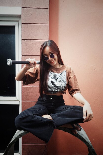 Photo young woman sitting against wall