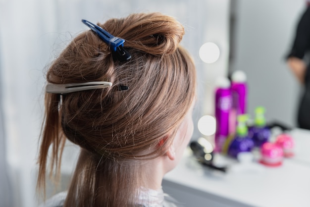 Young woman sitting in beauty hair salon style and waiting for hairdresser to make hairdo