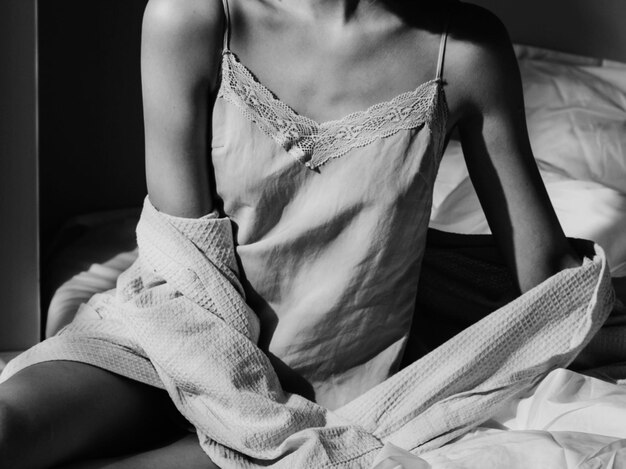 Young woman sitting on bed at home