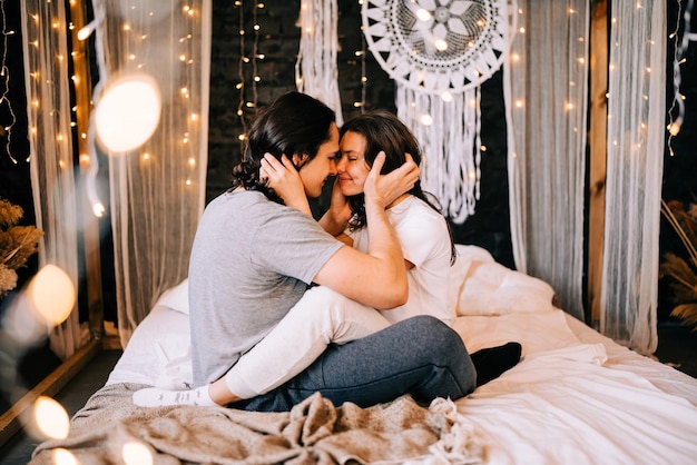 Photo young woman sitting on bed at home