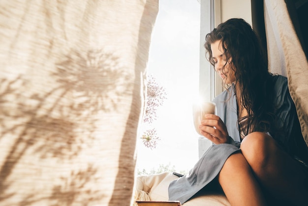young woman sitting on bed at home