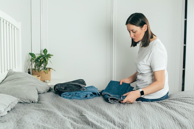 young woman sitting on bed at home
