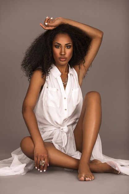 Photo young woman sitting on bed at home