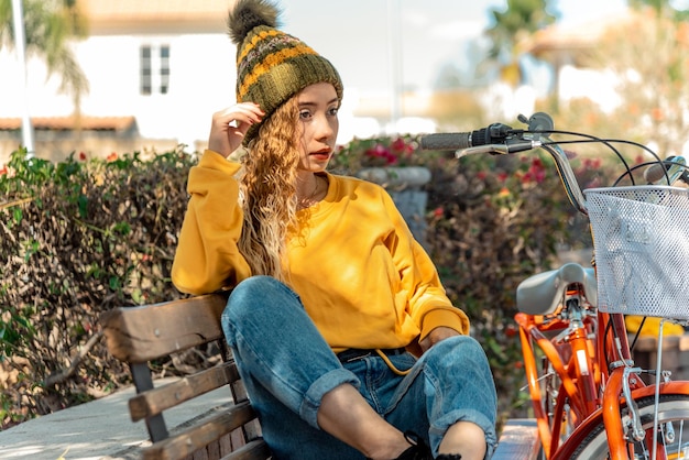 Young woman sitting on a bench admiring the view in a beautiful park outdoor