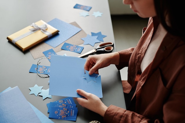 Photo young woman sitting by desk and preparing handmade hanukkah gifts