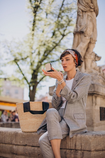 Young woman sitting by the fountain