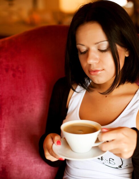 Young woman sitting in a cafe drinking coffee