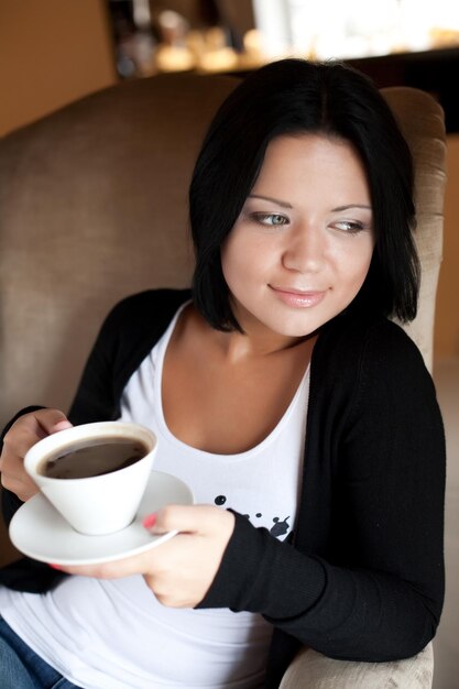 Young woman sitting in a cafe drinking coffee