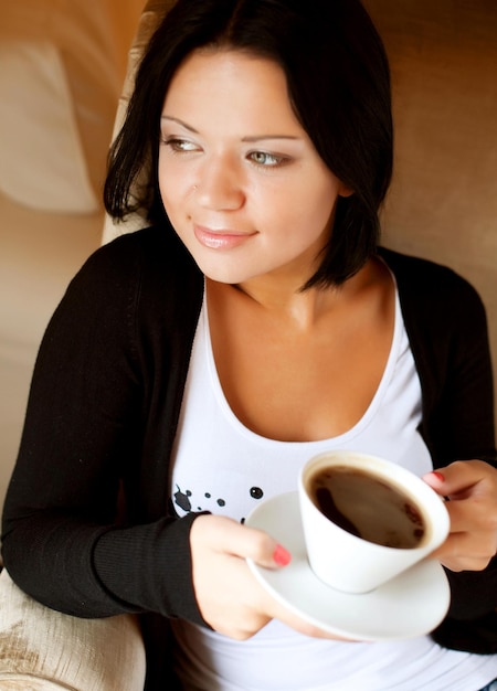 Young woman sitting in a cafe drinking coffee