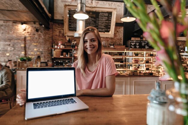 Young woman sitting in cafe, with laptop on table