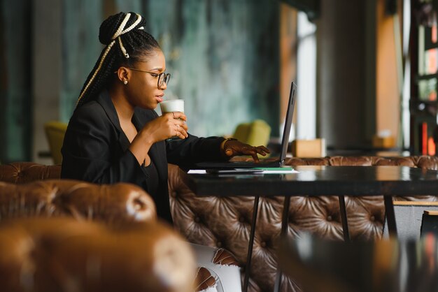 Young woman sitting in a cafe working on a laptop