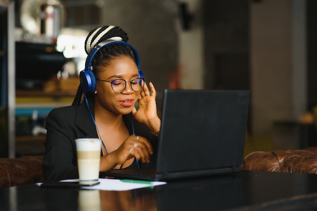 Young woman sitting in a cafe working on a laptop