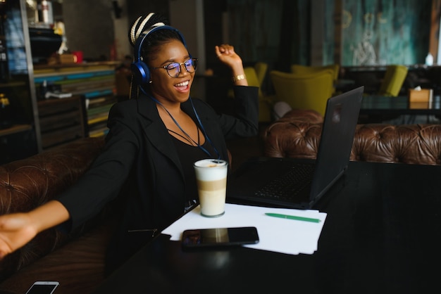 Young woman sitting in a cafe working on a laptop