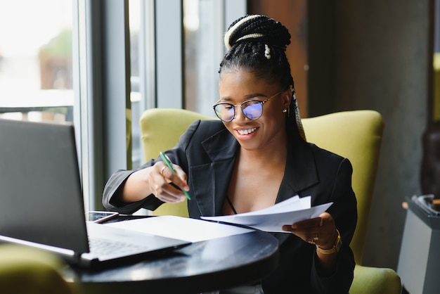 Young woman sitting in a cafe working on a laptop