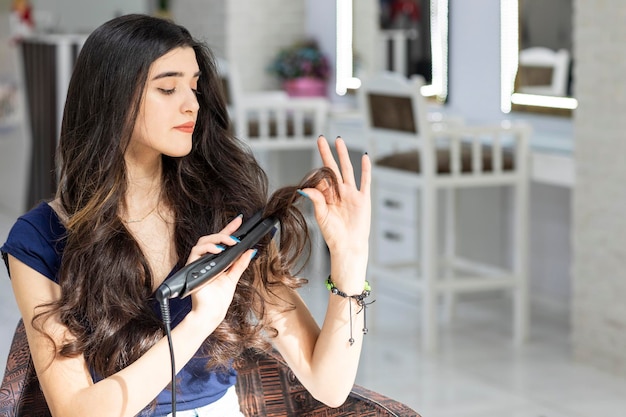 Young woman sitting on a chair and using hair dryer High quality photo