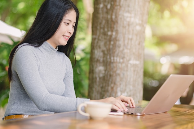 木製のテーブルでコーヒーショップに座っていた若い女性