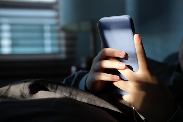 Young woman sitting on couch and using smart phone