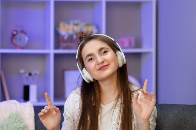 Young Woman Sitting on Couch While Listening to Music Through Headphone