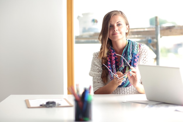 Young woman sitting at a desk among books Student