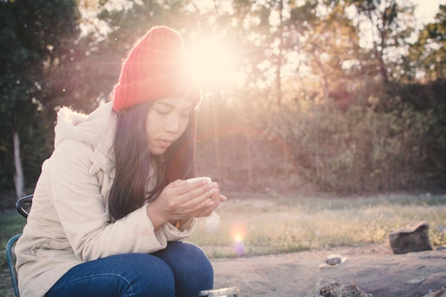 Photo young woman sitting in field during sunny day