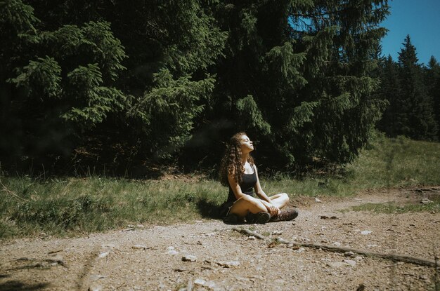 Photo young woman sitting on field