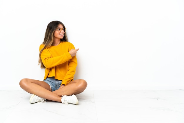 Молодая женщина, сидящая на изолированном полу