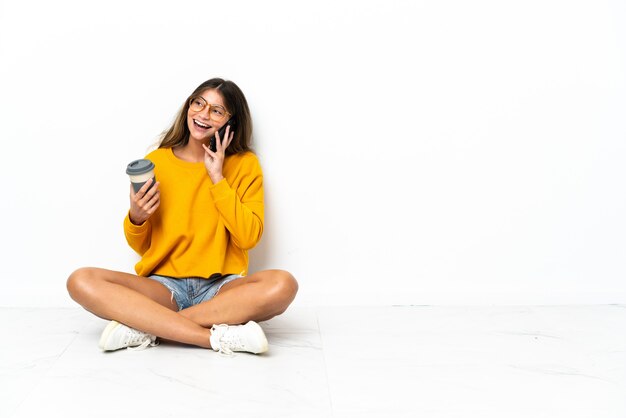 Young woman sitting on the floor isolated