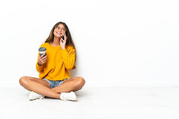 Young woman sitting on the floor isolated