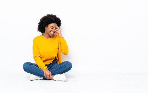 Young woman sitting on the floor laughing