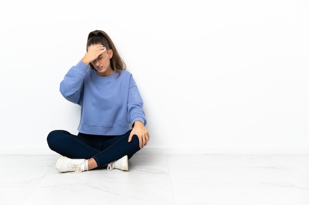 Photo young woman sitting on the floor with headache