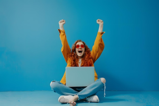 Photo young woman sitting on the floor with her laptop