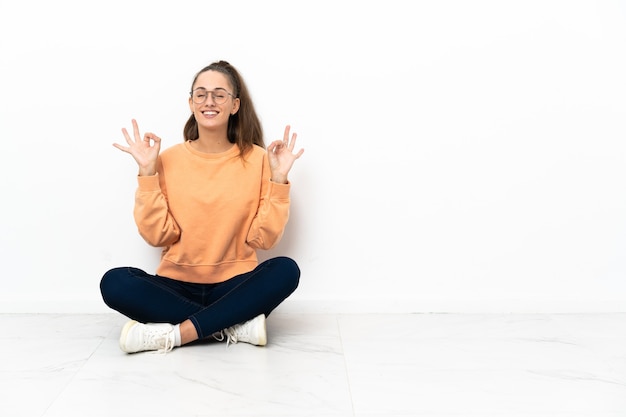 Young woman sitting on the floor in zen pose