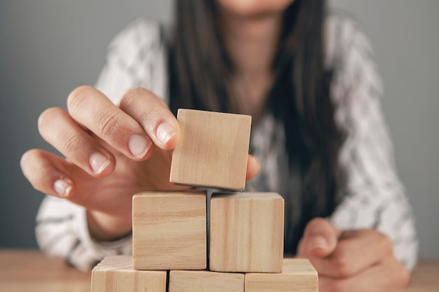 Young woman sitting in front of a pyramid of cubes