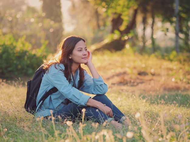 Photo young woman sitting on grassy field