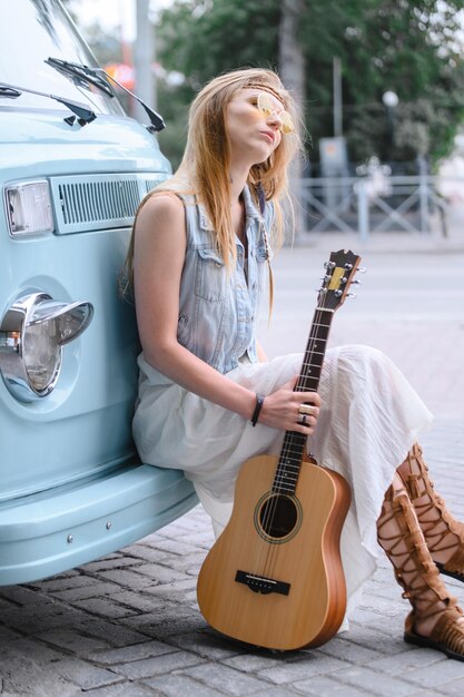 Young woman sitting on guitar