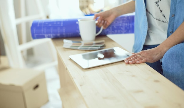 Photo young woman sitting at home and buying new furniture over the internet using a tablet computer