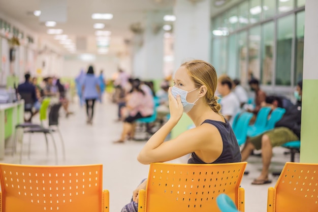 Young woman sitting in hospital waiting for a doctor's appointment Patients In Doctors Waiting Room