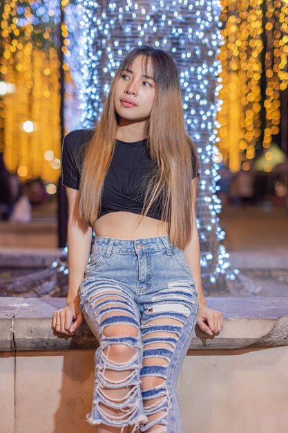 Photo young woman sitting in illuminated city
