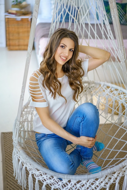 Young woman sitting in a knitted hammock