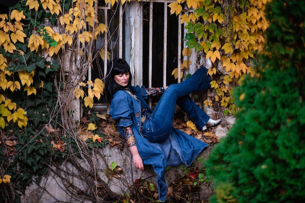 Photo young woman sitting on leaves during autumn