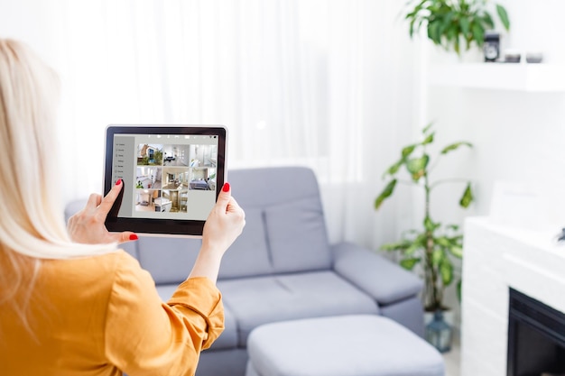 young woman sitting at modern home using smart home station.