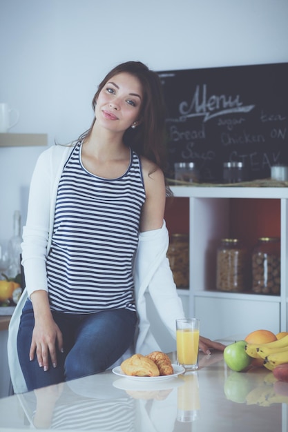 Young woman sitting near desk in the kitchen