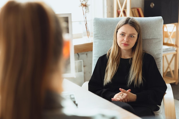 Foto giovane donna seduta in ufficio durante il colloquio di lavoro con una dipendente, un capo o un responsabile delle risorse umane