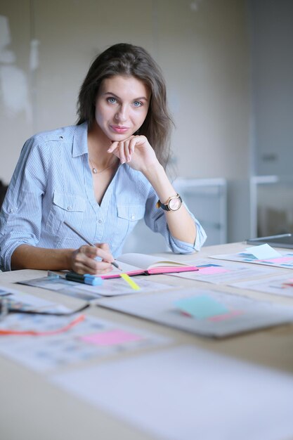 Young woman sitting in office table looking at laptop computer screen