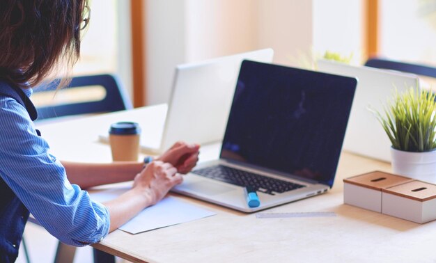 Young woman sitting at office table with laptop young woman\
laptop