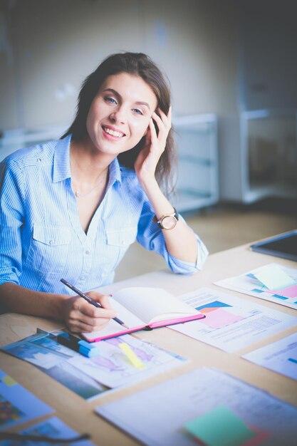 Young woman sitting at office table Young woman