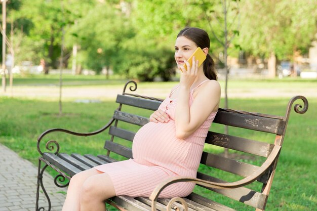 写真 公園のベンチに座っている若い女性