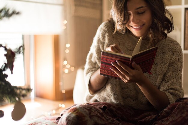 写真 本の上に座っている若い女性