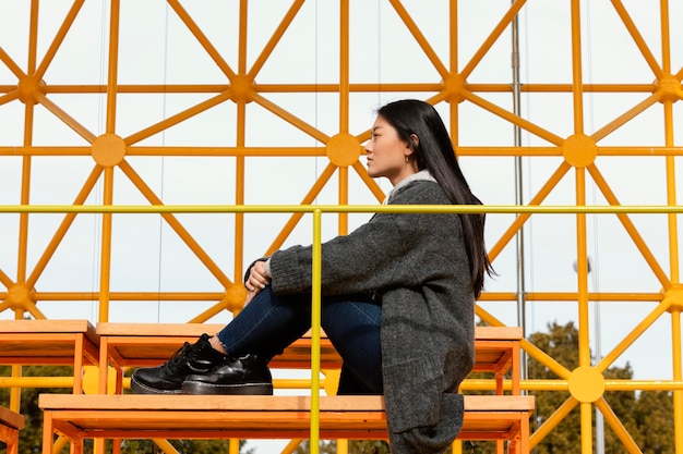 写真 サイト建設橋に座っている若い女性