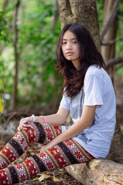 写真 木の上に座っている若い女性